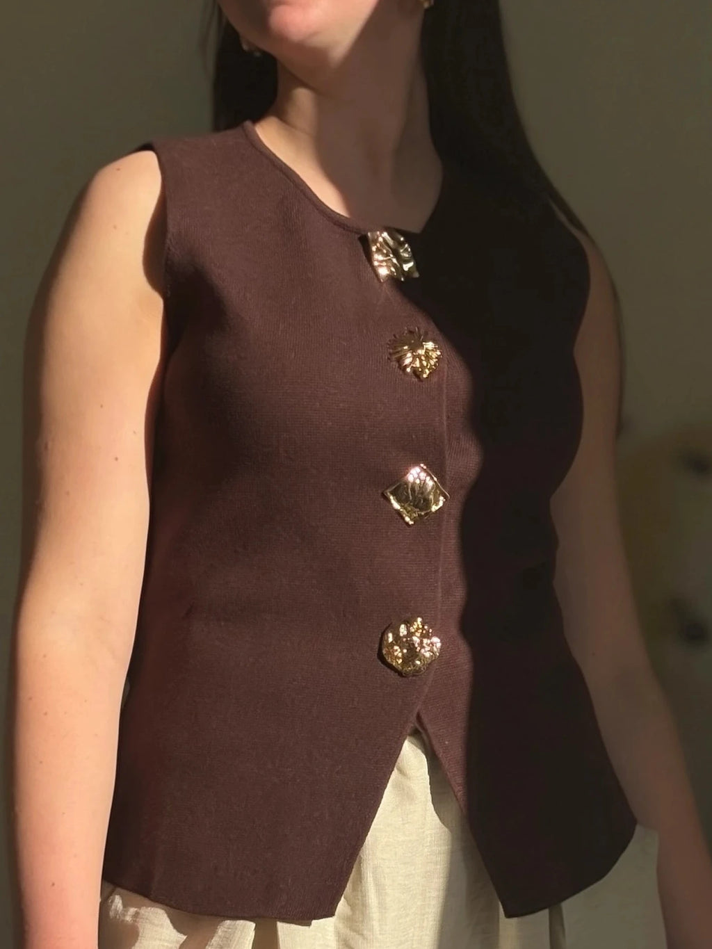 fille qui porte un haut marron avec des bijoux en bouton