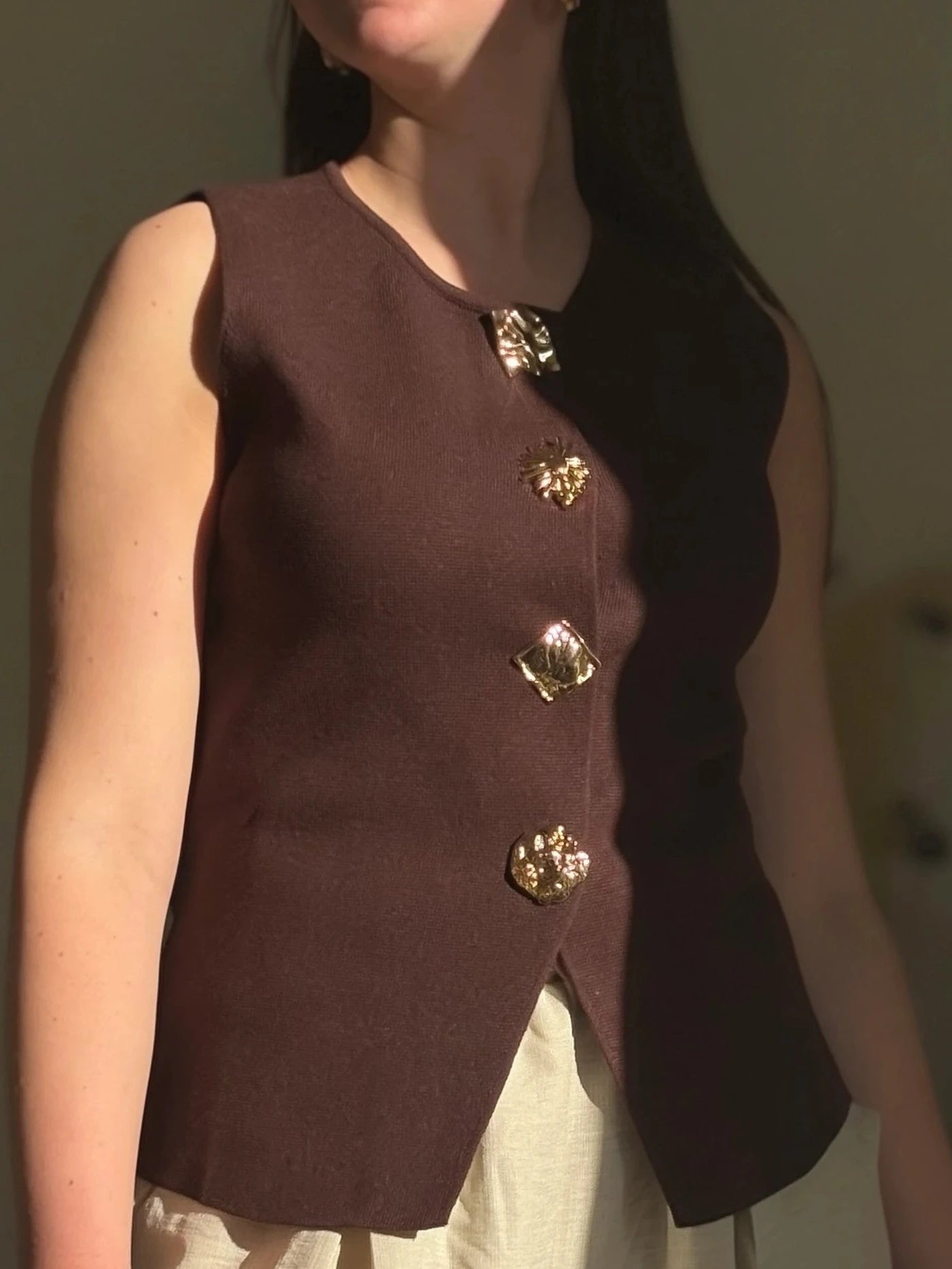 fille qui porte un haut marron avec des bijoux en bouton